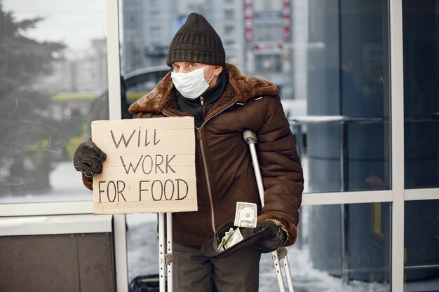 Kostenloses Foto obdachlose stehen in der nähe des gebäudes.