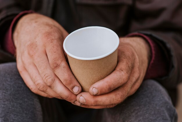 Obdachloser, der Tasse hält