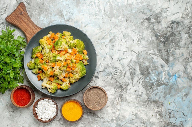 Oben Ansicht des gesunden Gemüsesalats verschiedene Gewürze und Brokkoli auf weißem Tisch