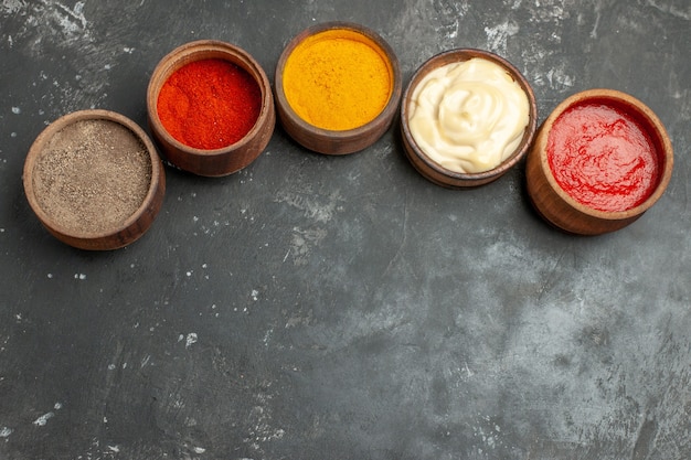 Kostenloses Foto oben ansicht des satzes für saucen, die verschiedene gewürze mayonnaise und ketchup auf grauem tisch enthalten