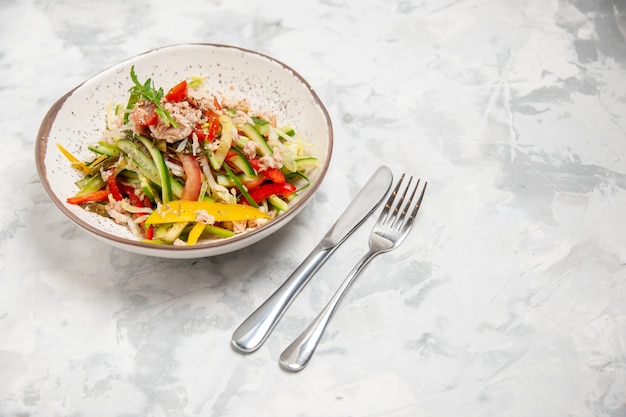 Oben Blick auf Hühnersalat mit Gemüse und Besteck auf weiß gebeizter Oberfläche