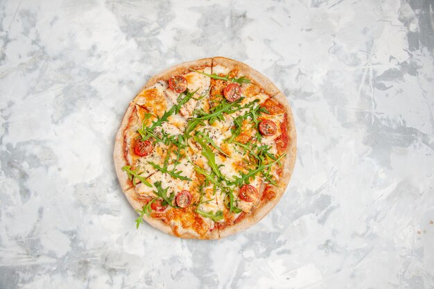 Oben Blick auf köstliche Pizza mit Tomatengrün auf gefärbter weißer Oberfläche mit freiem Platz