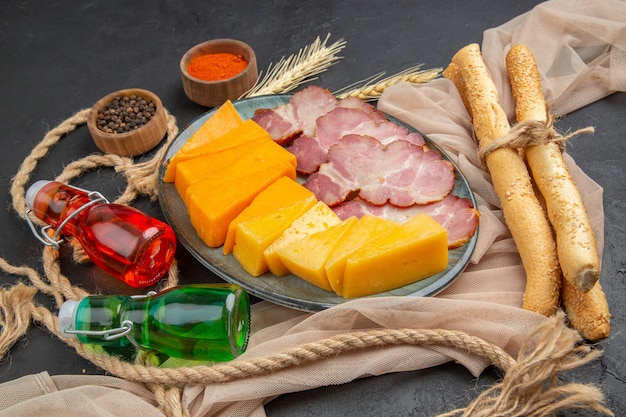 Oben Blick auf köstliche Snacks gefallene Flaschen Paprika auf Handtuch und Seil auf schwarzem Hintergrund