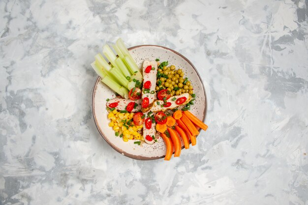 Oben Blick auf leckeren veganen Salat auf einem Teller auf weißer Fläche mit freiem Platz