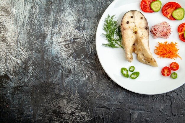 Oben Blick auf rohe Fische und frische Paprika-Lebensmittel auf weißem Teller auf der linken Seite auf Eisfläche mit Freiraum