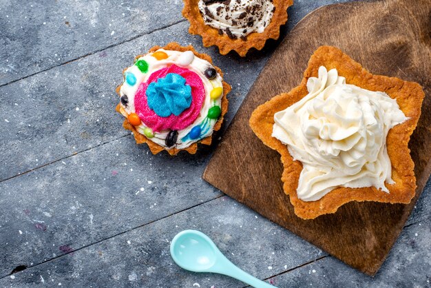 Oben nähere Ansicht des leckeren cremigen Kuchensterns geformt mit Plätzchenkuchen und blauem Löffel auf Licht