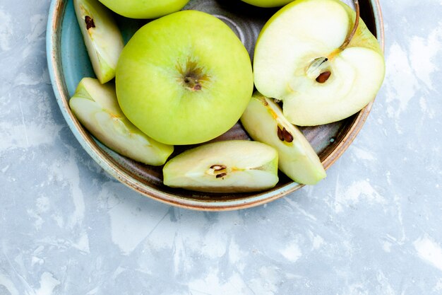 Oben nähere Ansicht frische grüne Äpfel in Scheiben geschnitten und ganze Früchte auf leichter Oberfläche Obst frisch ausgereift reifes Lebensmittel Vitamin