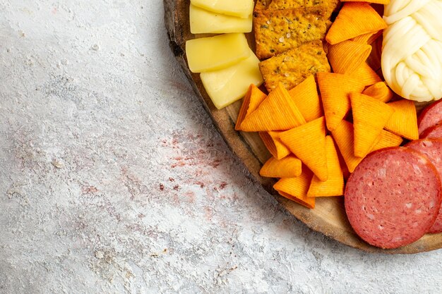 Oben Nahansicht verschiedene Snacks Cips Würstchen Käse und frische Trauben auf Weißraum