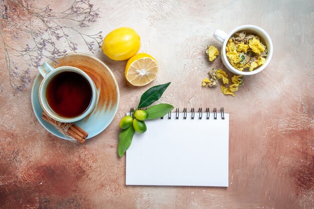 Oben Nahaufnahme Ansicht eine Tasse Tee eine Tasse Tee Zimt Zitronenweiß Notebook Kräuter