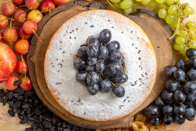 Oben Nahaufnahme Ansicht eines Kuchens ein Kuchen auf dem Brett Rosinen Kirschäpfel grüne und schwarze Trauben