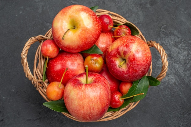 Oben Nahaufnahme Ansicht Obst Holzkorb mit Kirschen und Äpfeln