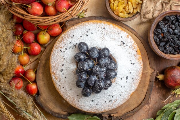 Oben Nahaufnahme eines Kuchens ein Kuchen Äpfel im Korb Schokoladensauce Beeren Rosinen Ährchen