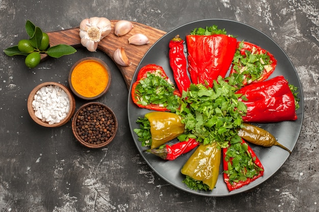 Oben Nahaufnahme Teller mit Paprika Teller mit geröstetem Paprika Knoblauch auf den Gewürzen des Schneidebretts