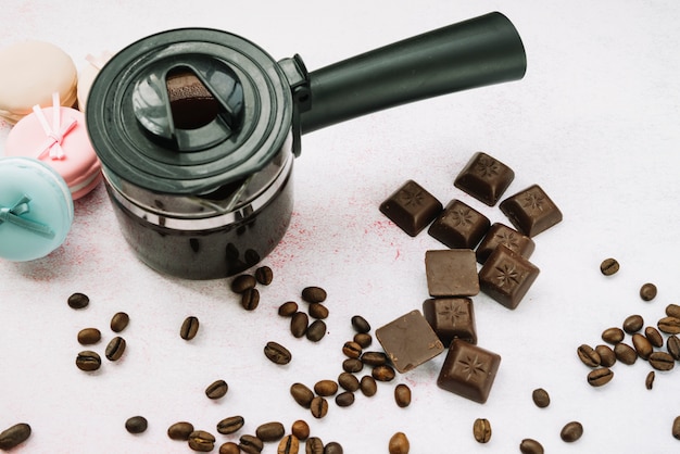 Kostenloses Foto obenliegende ansicht der kaffeemaschine mit schokoladenstücken und röstkaffeebohnen