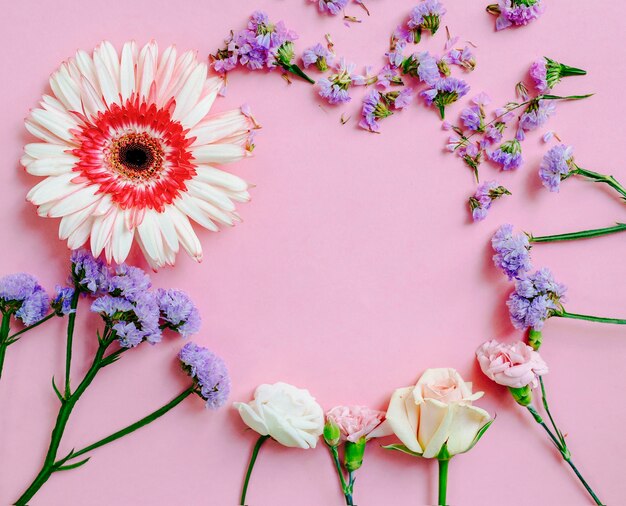 Obenliegende Ansicht des Blumenrahmens auf rosa Hintergrund