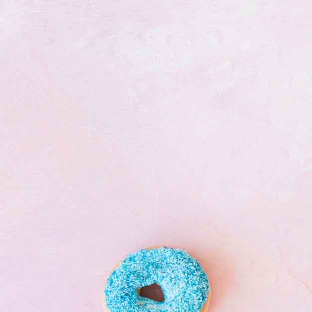 Obenliegende Ansicht des frischen blauen Donuts an der Unterseite des rosa Hintergrundes