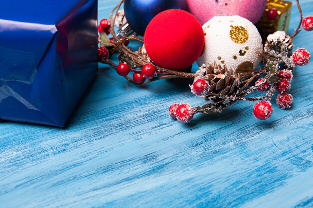 Obenliegende Ansicht des Weihnachtsgeschenks und der Dekoration über blauem hölzernem Hintergrund Auch im corel abgehobenen Betrag. Frohe Weihnachten