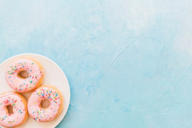 Obenliegende Ansicht von frischen rosa Donuts auf Platte