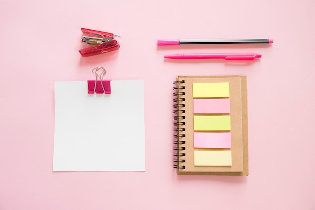 Obenliegende Ansicht von verschiedenen Schreibwaren auf rosa Hintergrund