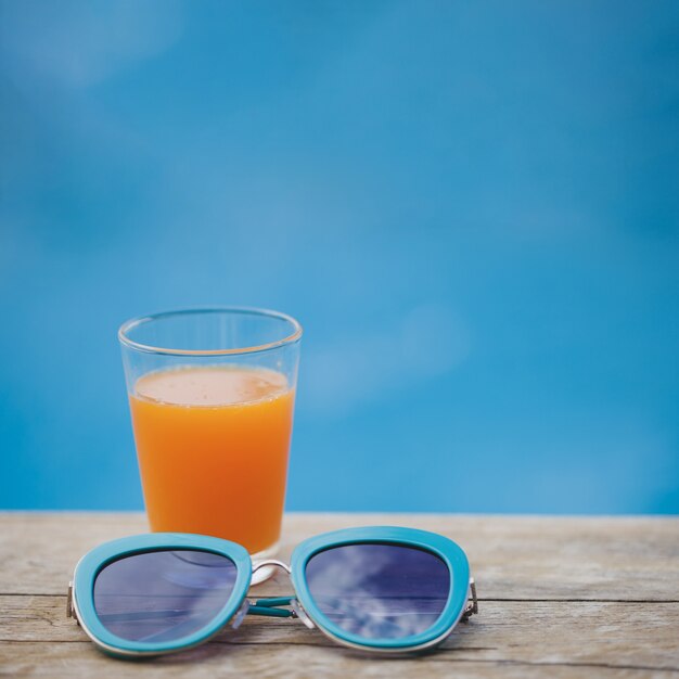 Oberfläche mit Getränk und blauer Sonnenbrille