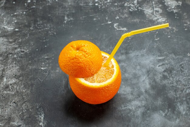 Oberhalb der Ansicht von organischem, natürlichem Schnitt frischer Orange mit Rohr auf grauem Hintergrund