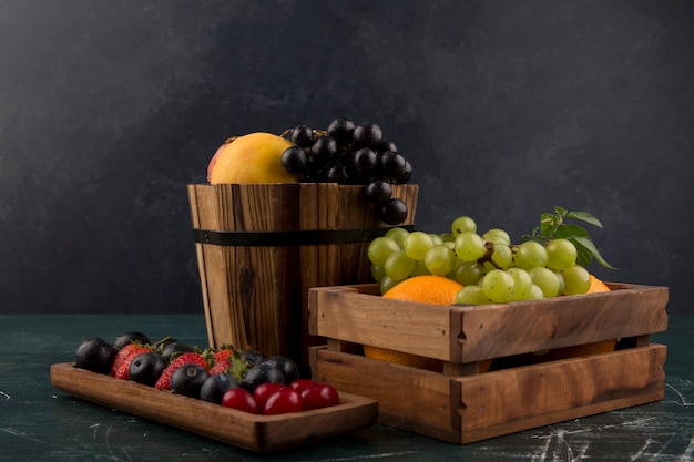 Obst und Beeren mischen sich in Holzbehältern