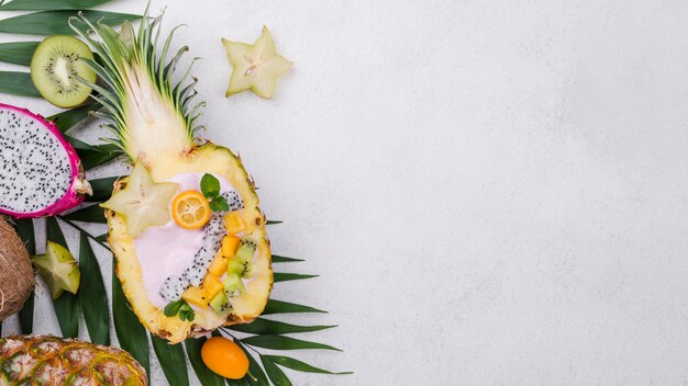 Obstsalat in der Hälfte des Ananas-Kopierraums