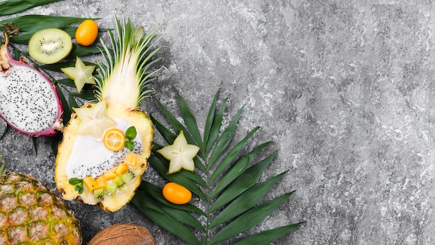 Obstsalat in der Hälfte des Ananas-Kopierraums