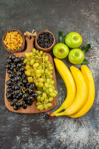 Obstschalen mit getrockneten Früchten Äpfel Bananen und Trauben auf dem Küchenbrett