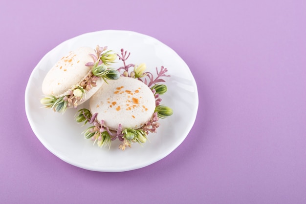 Kostenloses Foto Öko-macarons mit blumen auf dem hohen winkel der platte