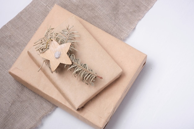 Öko-papiertüten verziert mit bändern und getrockneten tannenzweigbändern und tannenzapfen