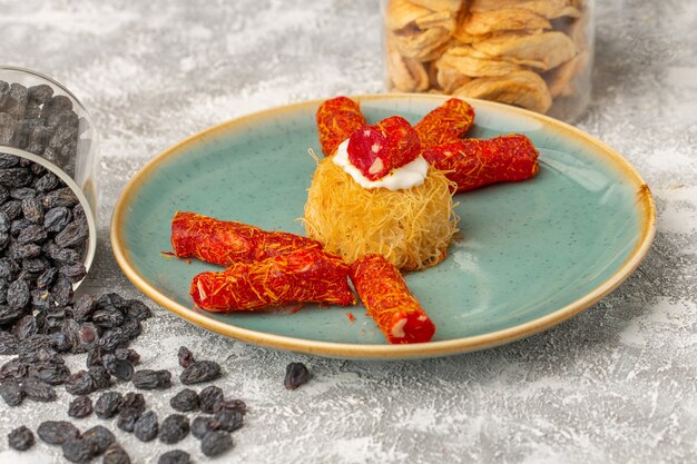 östliche Gebäckkekse in Teller mit weißer Creme und kleinen roten Confitures