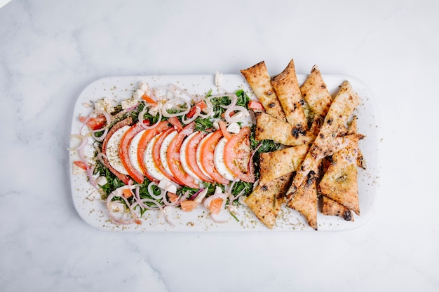 Ofenchips mit grünen Salat-, Gemüse- und Tomatenscheiben.