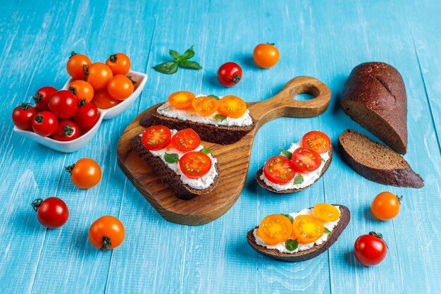 Offene Sandwiches mit Hüttenkäse, Kirschtomaten und Basilikum.