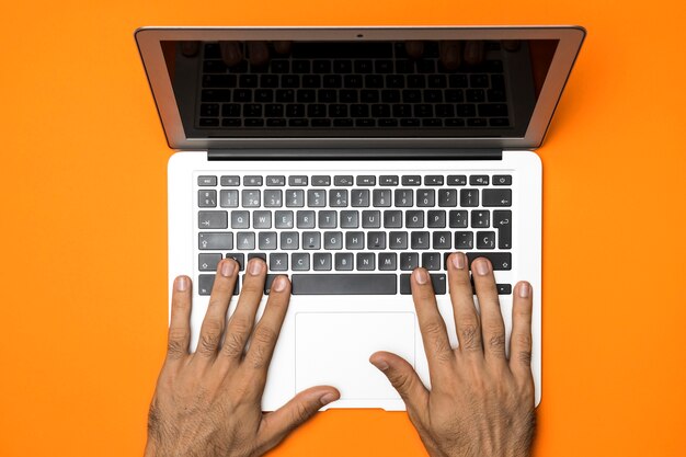 Offener Laptop der Draufsicht mit orange Hintergrund