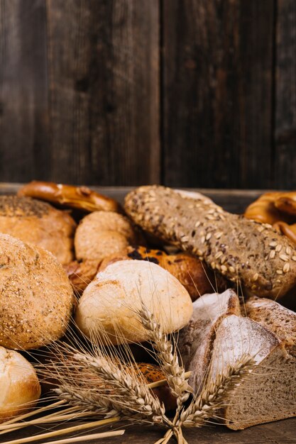 Ohr des Weizens vor gebackenem Brot auf Holztisch