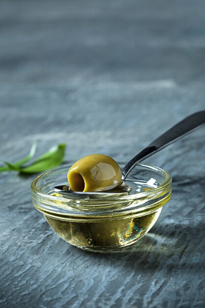 Olivenöl und Olivenzweig auf Holztisch