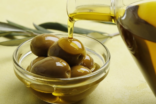 Olivenöl wird auf oliven nahaufnahme gegossen. grüne oliven.