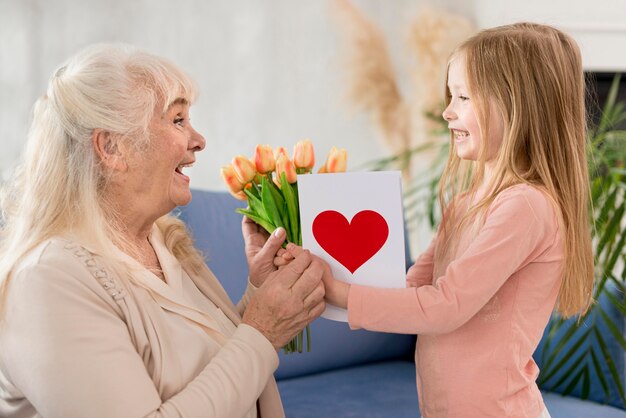 Oma mit Blumen vom kleinen Mädchen