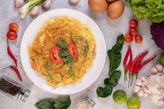 Omelett in einem weißen Teller, garniert mit Tomaten und Koriander.