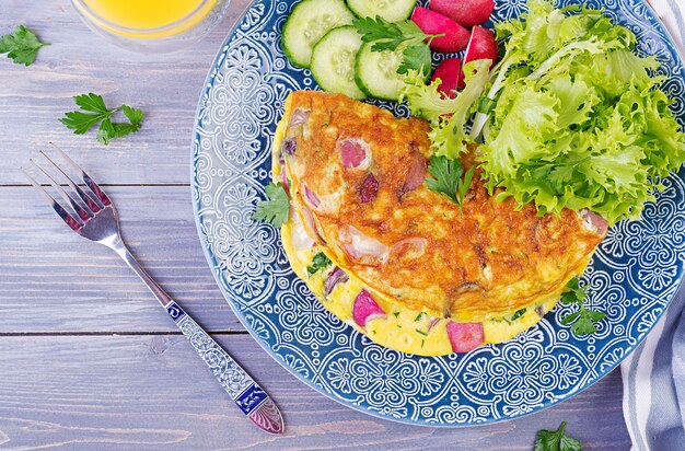 Omelett mit Radieschen, roten Zwiebeln und frischem Salat