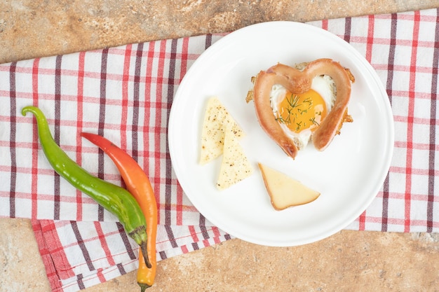 Omelett mit Wurst in weißer Platte auf Tischdecke