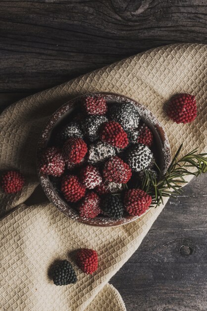 Onhead-Aufnahme der frischen Beeren auf einem mit Zuckerpulver übergossenen Küchentuch