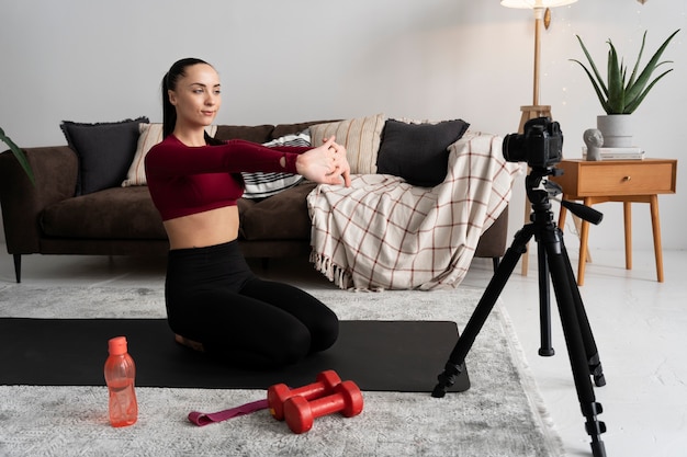 Kostenloses Foto online-sport-fitness-trainerin, die ihre sitzung aufzeichnet