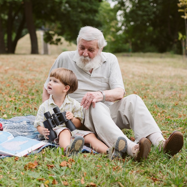 Opa und Enkel im Park mit Fernglas