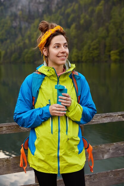 Optimistische schöne weibliche Modell trecks im Freien an Ort und Stelle mit fantastischen Landschaften