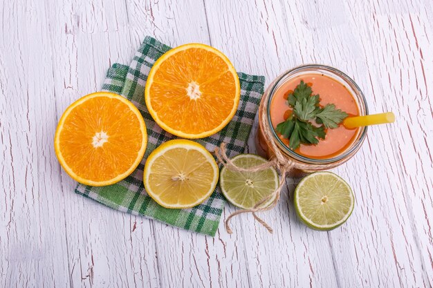 Orange detox coctail mit halb orange und kalk liegt auf dem tisch