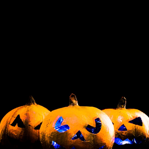 Orange handgemachte Kürbisse mit geschnitzten Gesichtern in Halloween-Stil