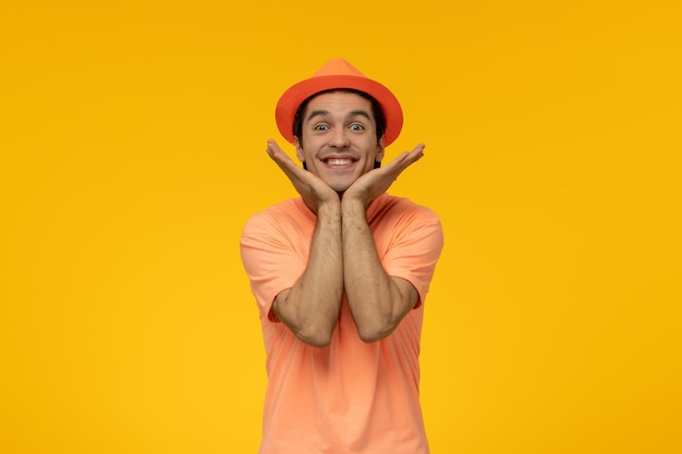 Orange Hut hübscher hübscher Kerl im orangefarbenen T-Shirt mit dem Hut super glücklich und lächelnd