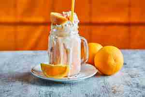 Kostenloses Foto orange smoothie mit streuseln und stroh auf dem weißen teller